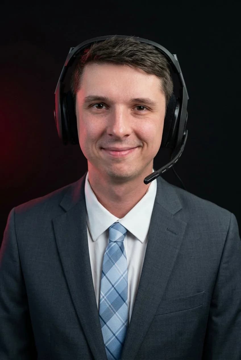 Sam wearing a gray suit, patterned tie, and gaming headset